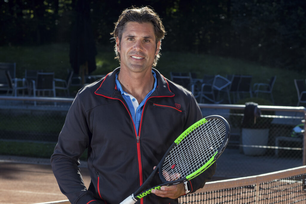 Sven Melig, Gründer und Leiter der Kids Sportcamps, mit Tennisschläger auf dem Tennisplatz.